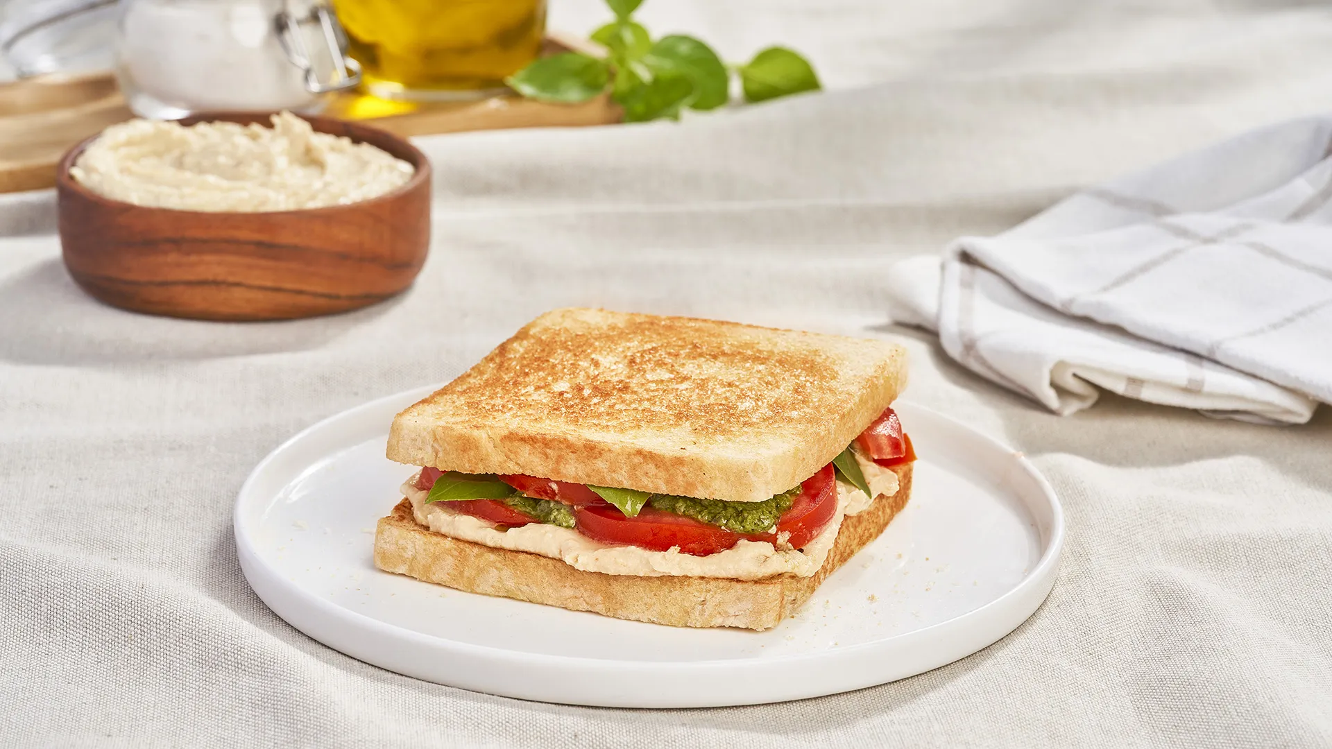 Sanduíche com húmus, tomate e pesto de manjericão