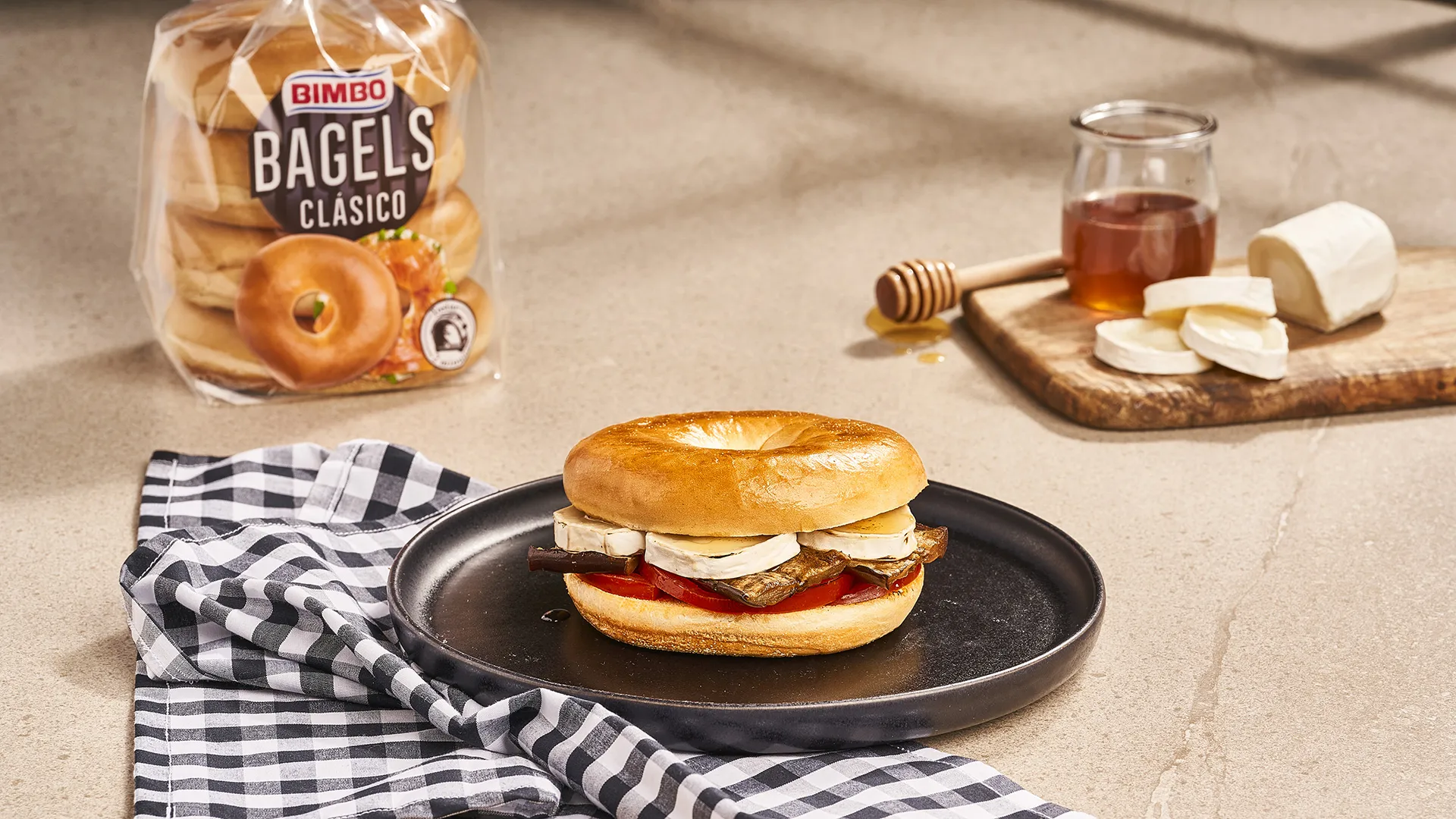 Bagel com beringela assada, tomate e queijo de cabra com mel
