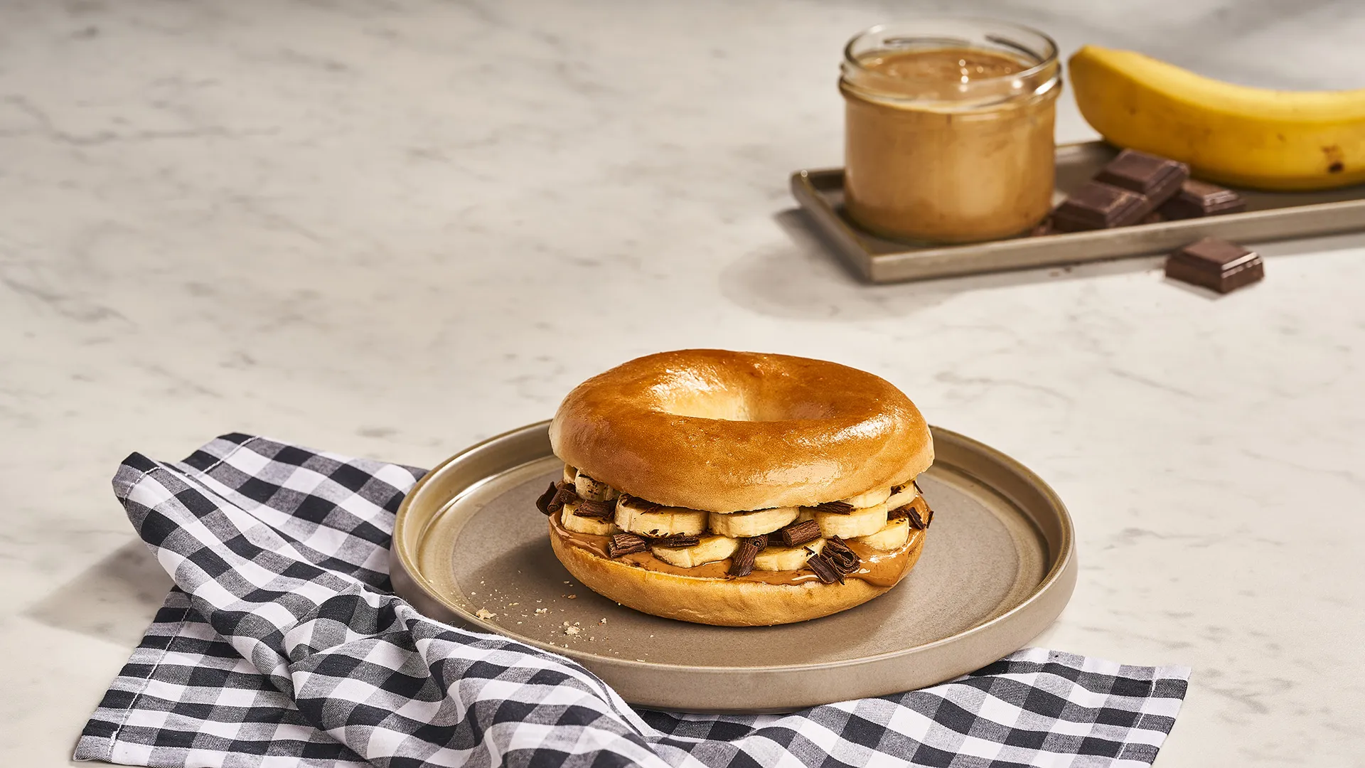 Bagel com manteiga de amendoim, banana e chocolate preto