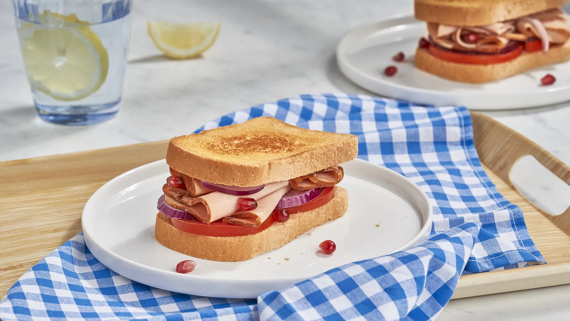 Sanduíche de peru braseado, com tomate, cebola roxa e romã