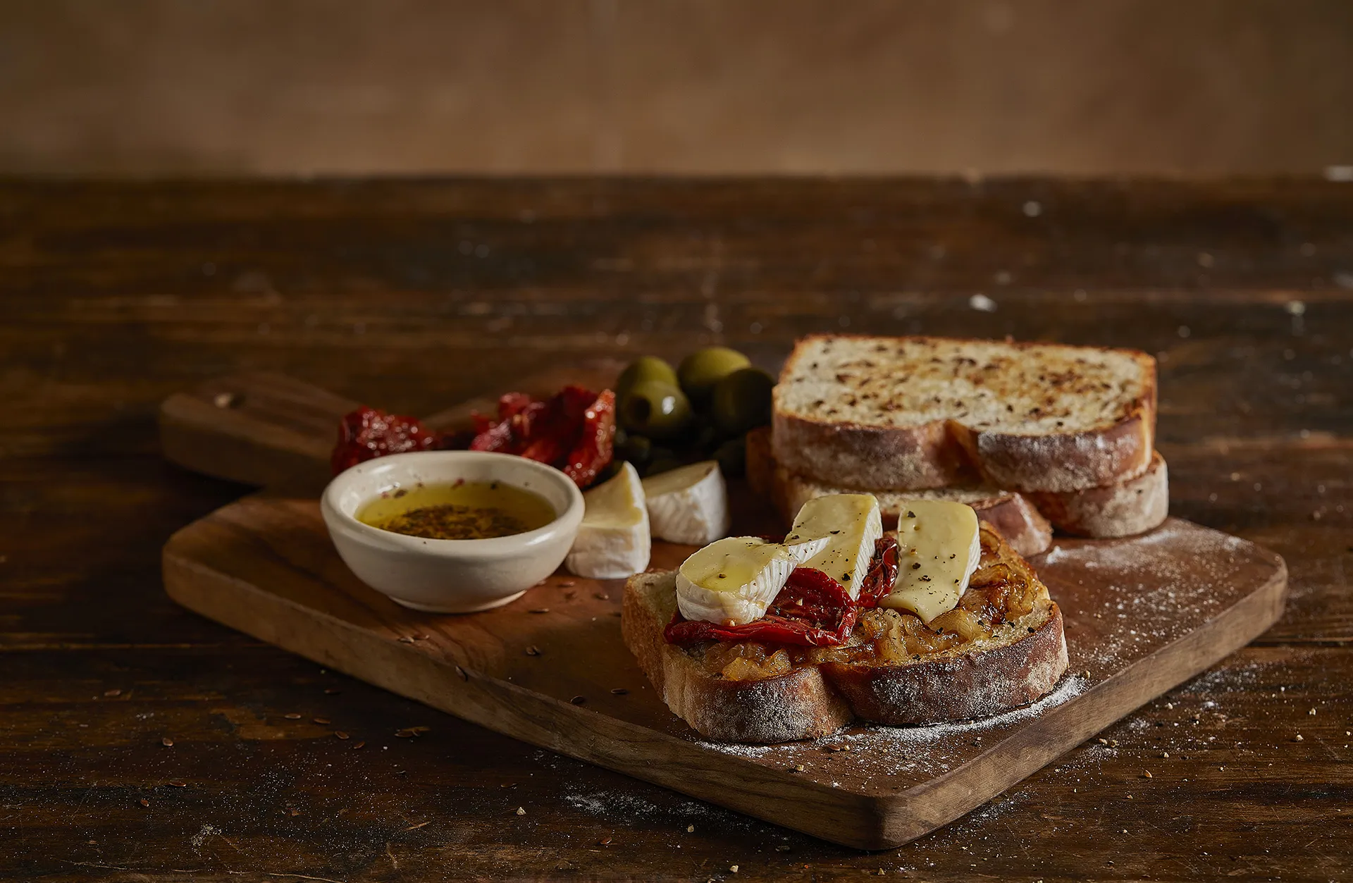 Tábua de petiscos com queijo brie, cebola caramelizada e tomates secos