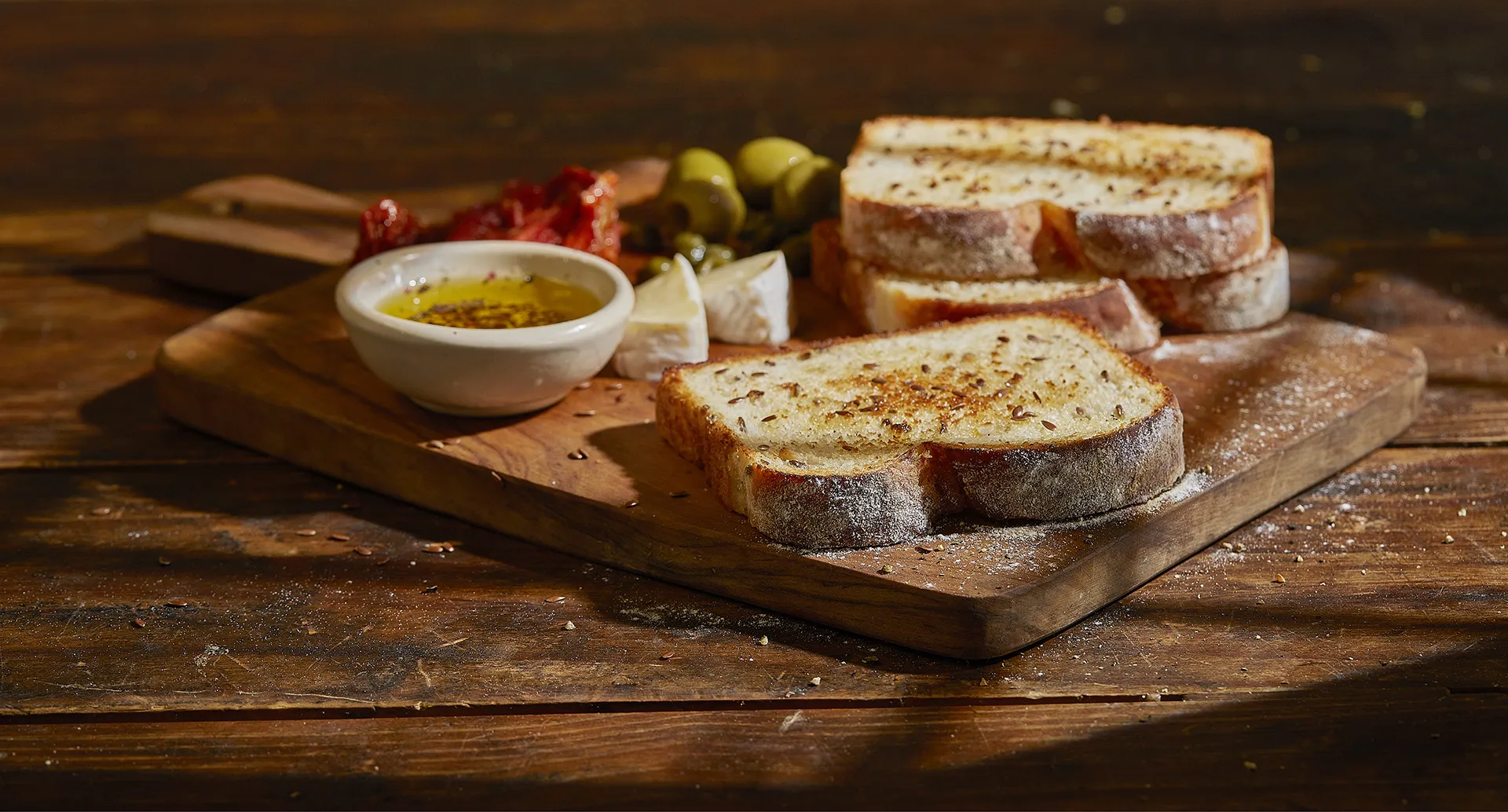 Tábua de petiscos com queijo brie, cebola caramelizada e tomates secos