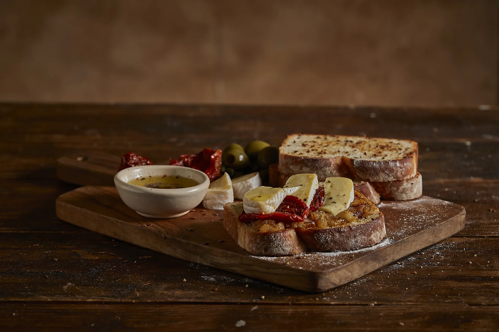 Tábua de petiscos com queijo brie, cebola caramelizada e tomates secos