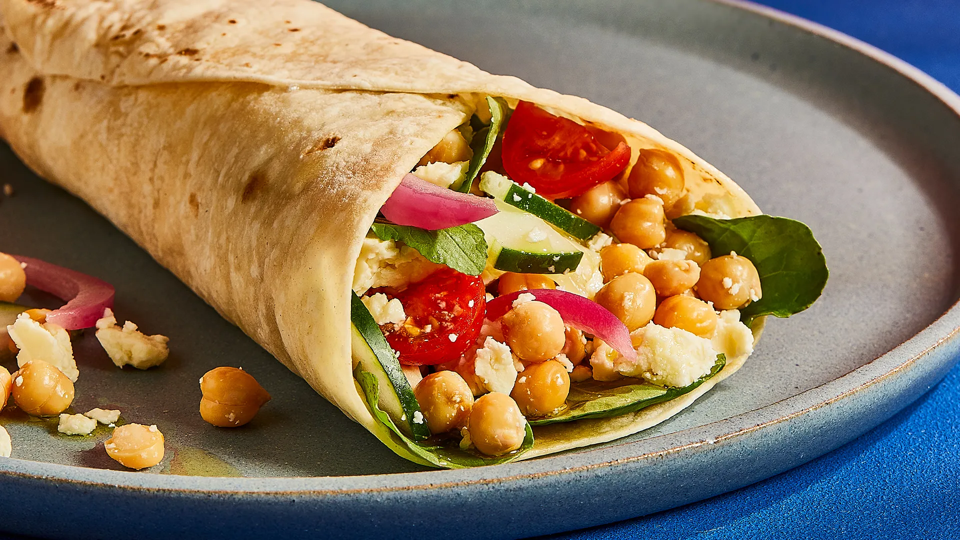 Wrap de queijo, pepino, tomate, grão, rebentos e cebola